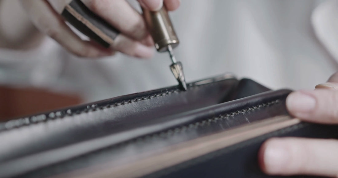 Détail de fabrication d’un sac à main avec finition du cuir en atelier.